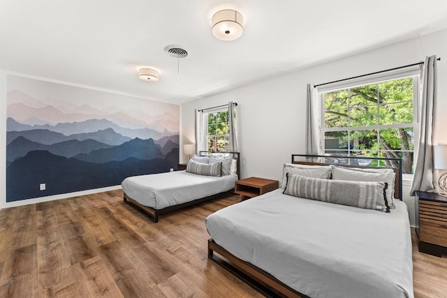 bedroom featuring visible vents and wood finished floors