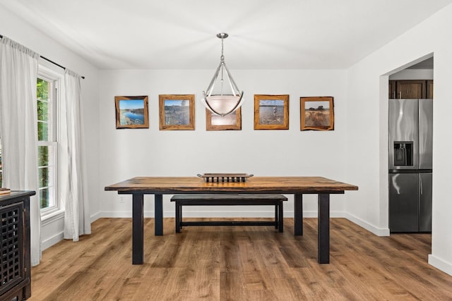 dining space featuring wood finished floors and baseboards