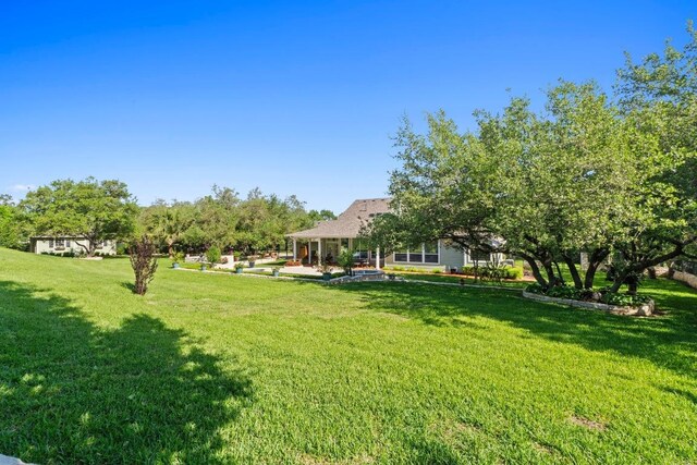 135 N Tumbleweed Trl, Austin, TX 78733 - view of green lawn with a patio area
