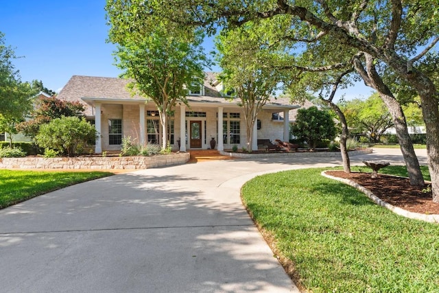 135 N Tumbleweed Trl, Austin, TX 78733 - view of front of property featuring covered porch, stone siding, and curved driveway