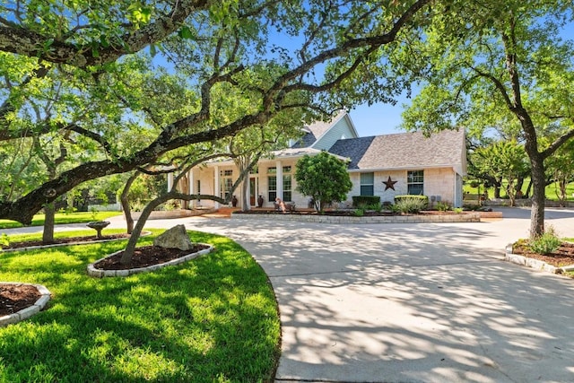 135 N Tumbleweed Trl, Austin, TX 78733 - view of front of property featuring a front lawn, curved driveway, and a shingled roof