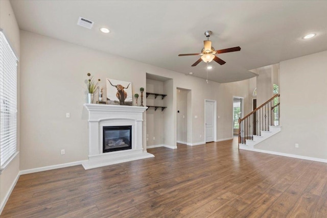 2604 Outlook Ridge Loop, Leander, TX 78641 - unfurnished living room with wood finished floors, stairs, ceiling fan, a glass covered fireplace, and baseboards