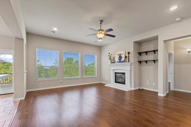2604 Outlook Ridge Loop, Leander, TX 78641 - unfurnished living room featuring a ceiling fan, baseboards, a glass covered fireplace, hardwood / wood-style floors, and recessed lighting