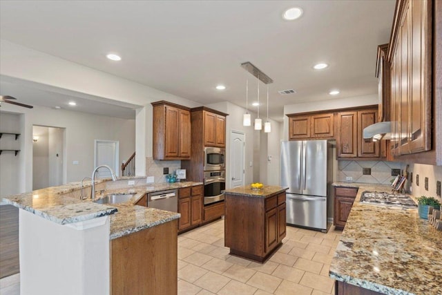 2604 Outlook Ridge Loop, Leander, TX 78641 - kitchen featuring stainless steel appliances, a sink, a peninsula, backsplash, and light stone countertops