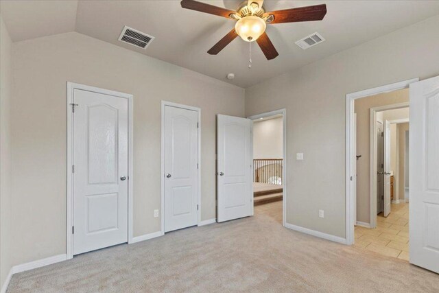 2604 Outlook Ridge Loop, Leander, TX 78641 - unfurnished bedroom featuring light colored carpet, baseboards, multiple closets, vaulted ceiling, and ceiling fan