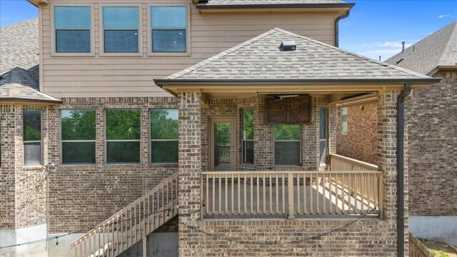 2604 Outlook Ridge Loop, Leander, TX 78641 - rear view of house featuring a shingled roof, stairs, and brick siding
