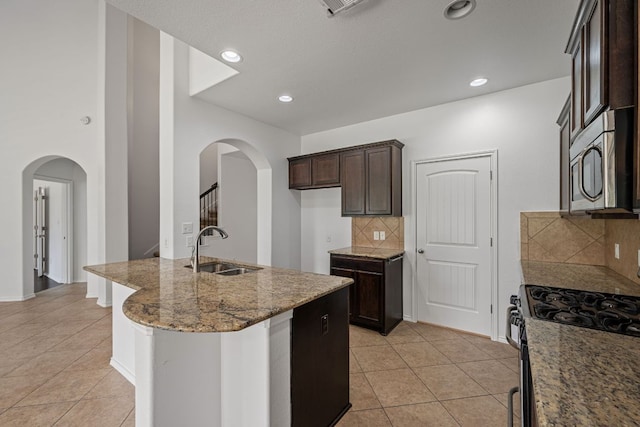 188 Rock Vista Run, Austin, TX 78737 - kitchen with a sink, stainless steel microwave, light tile patterned floors, arched walkways, and recessed lighting