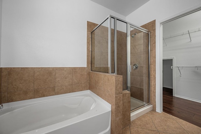 188 Rock Vista Run, Austin, TX 78737 - bathroom with a garden tub, a shower stall, a walk in closet, and tile patterned floors