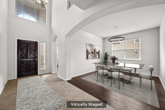 188 Rock Vista Run, Austin, TX 78737 - entryway with arched walkways, tile patterned floors, a chandelier, and baseboards