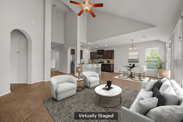188 Rock Vista Run, Austin, TX 78737 - living room featuring arched walkways, light tile patterned flooring, ceiling fan, baseboards, and high vaulted ceiling