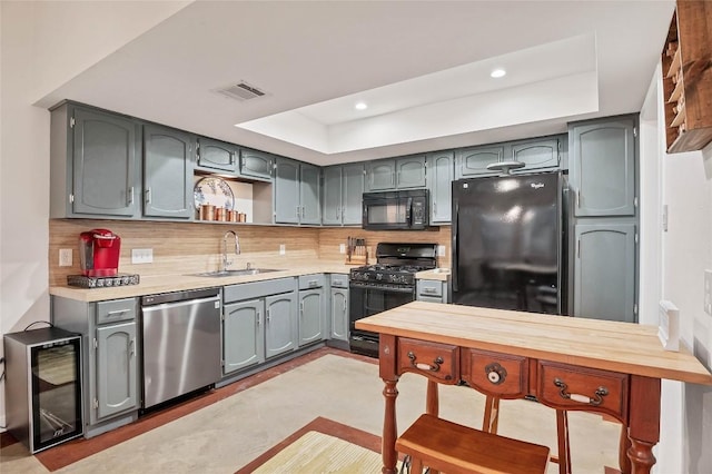 9458 Singing Quail Dr, Austin, TX 78758 - kitchen with black appliances, a tray ceiling, beverage cooler, light countertops, and open shelves