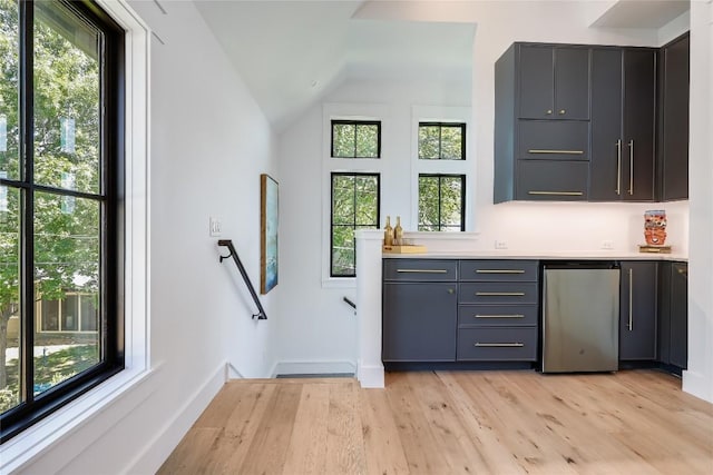 bar with plenty of natural light, lofted ceiling, refrigerator, and bar
