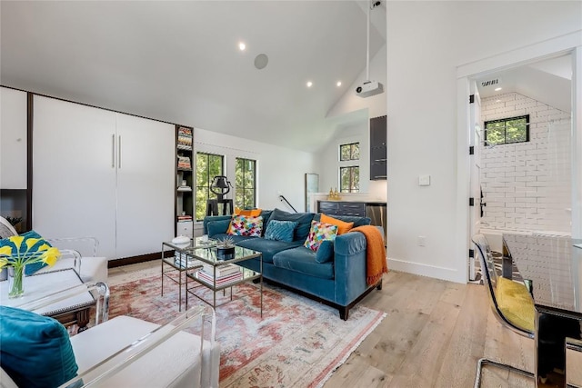 living room featuring recessed lighting, high vaulted ceiling, baseboards, and light wood-style flooring