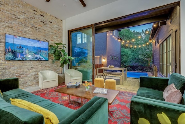 living area with brick wall and ceiling fan