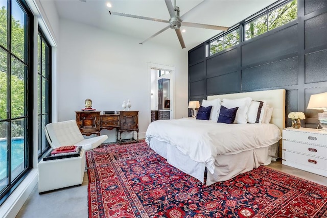 bedroom featuring a towering ceiling and multiple windows