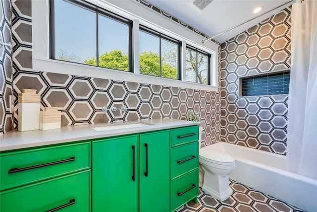 full bathroom featuring washtub / shower combination, backsplash, visible vents, toilet, and vanity