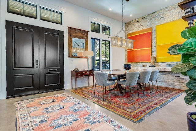 dining room featuring concrete flooring, a high ceiling, and recessed lighting