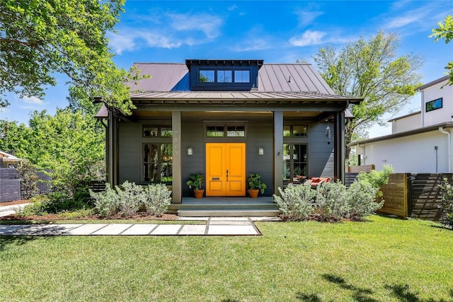 exterior space featuring a front yard, covered porch, a standing seam roof, and metal roof
