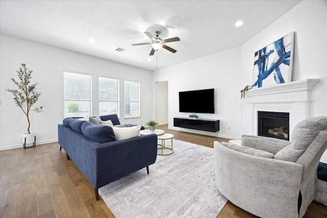 2216 Lookout Knoll Dr, Leander, TX 78641 - living area with a ceiling fan, wood finished floors, a glass covered fireplace, recessed lighting, and baseboards