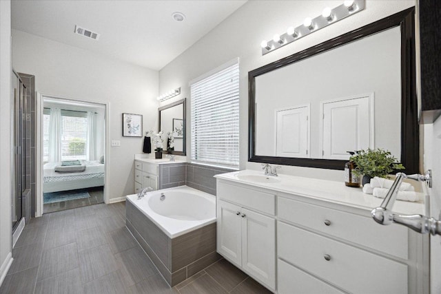 2216 Lookout Knoll Dr, Leander, TX 78641 - full bath featuring two vanities, a garden tub, a shower stall, connected bathroom, and tile patterned floors