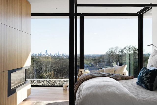 4607 Laurel Canyon Dr, Austin, TX 78731 - bedroom with multiple windows, floor to ceiling windows, light wood-style flooring, a fireplace, and a view of skyline