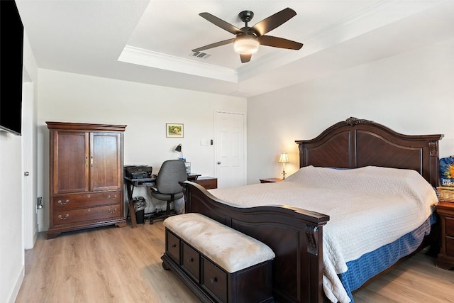 11604 Gaelic Dr, Austin, TX 78754 - bedroom with light wood-type flooring, a tray ceiling, a desk, ornamental molding, and a ceiling fan