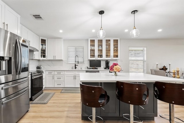 11604 Gaelic Dr, Austin, TX 78754 - kitchen featuring appliances with stainless steel finishes, a breakfast bar area, light countertops, white cabinets, and recessed lighting