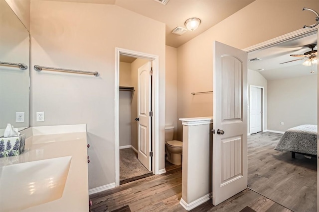 1432 Blake St, Leander, TX 78641 - full bath featuring wood finished floors, lofted ceiling, toilet, ceiling fan, and double vanity