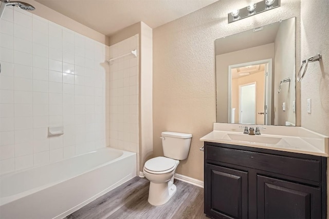 1432 Blake St, Leander, TX 78641 - bathroom with toilet, wood finished floors, vanity, shower / bathtub combination, and a textured wall