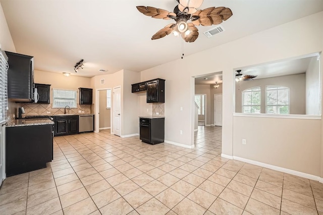 1432 Blake St, Leander, TX 78641 - kitchen with a ceiling fan, stainless steel dishwasher, dark cabinetry, and decorative backsplash