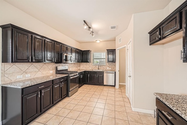 1432 Blake St, Leander, TX 78641 - kitchen with stainless steel appliances, light tile patterned floors, tasteful backsplash, and light stone counters