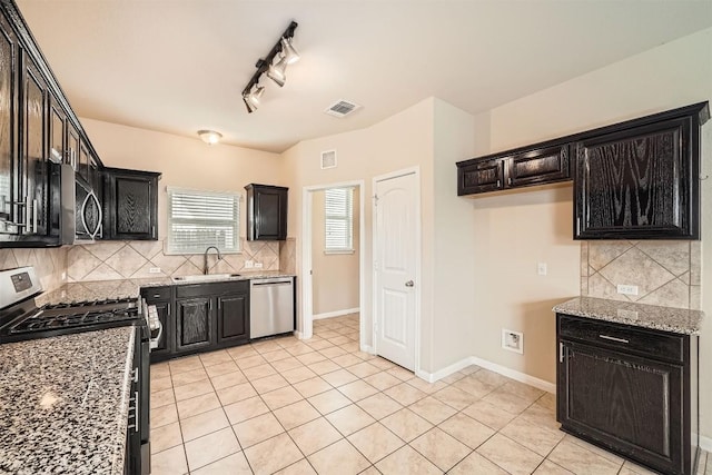 1432 Blake St, Leander, TX 78641 - kitchen featuring stainless steel appliances, a sink, backsplash, and light tile patterned floors