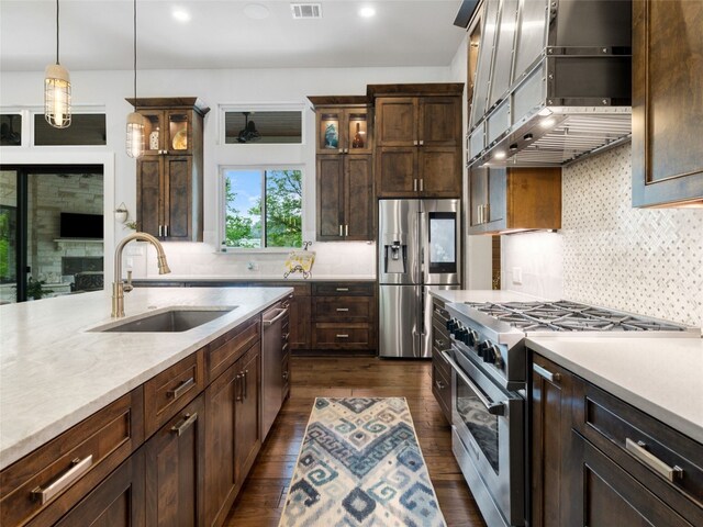 9806 Inca Ln, Austin, TX 78733 - kitchen featuring appliances with stainless steel finishes, dark wood-style flooring, light countertops, exhaust hood, and recessed lighting