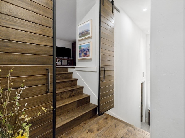 9806 Inca Ln, Austin, TX 78733 - staircase featuring wood-type flooring, a barn door, and recessed lighting