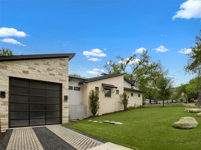 9806 Inca Ln, Austin, TX 78733 - view of property exterior featuring stone siding, driveway, a yard, a garage, and stucco siding