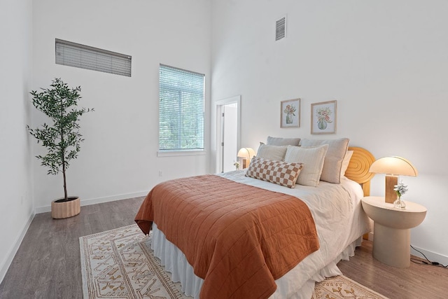 705 N Bluff Dr Unit 14, Austin, TX 78745 - bedroom featuring wood finished floors and a high ceiling