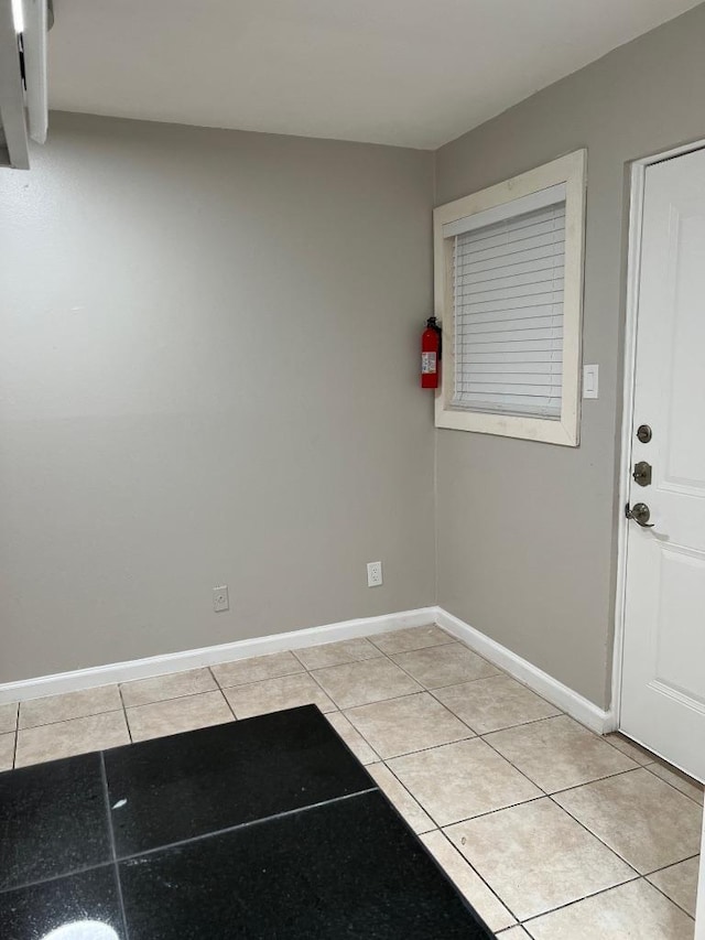interior space with baseboards and light tile patterned floors