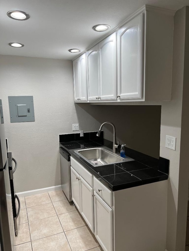 laundry area featuring a sink, electric panel, light tile patterned floors, baseboards, and recessed lighting
