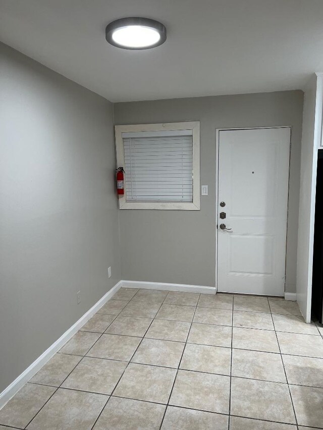 interior space featuring baseboards and light tile patterned floors