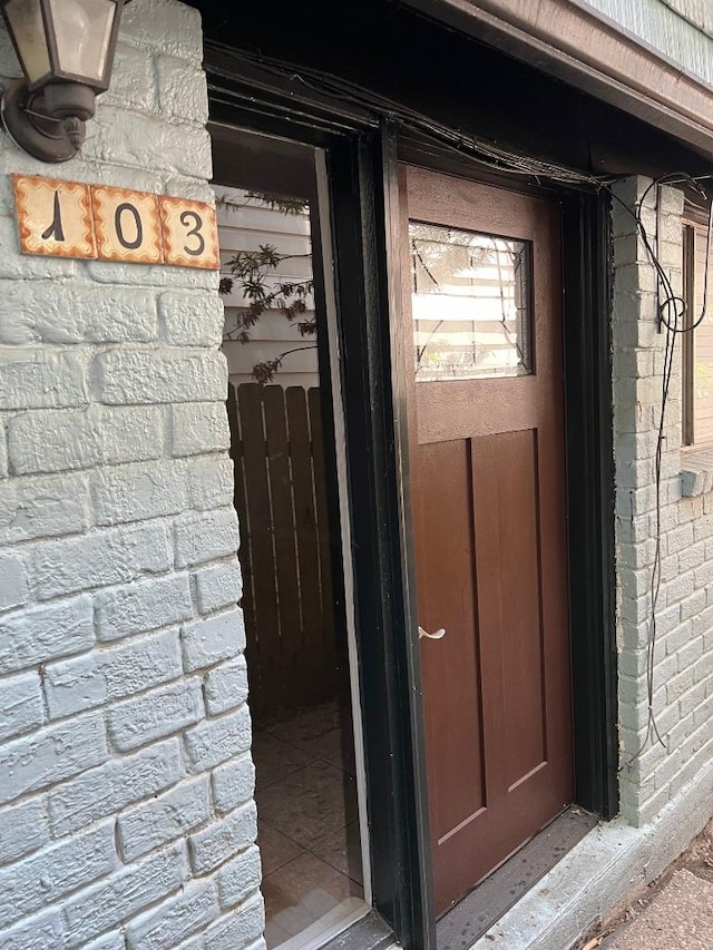 doorway to property with brick siding