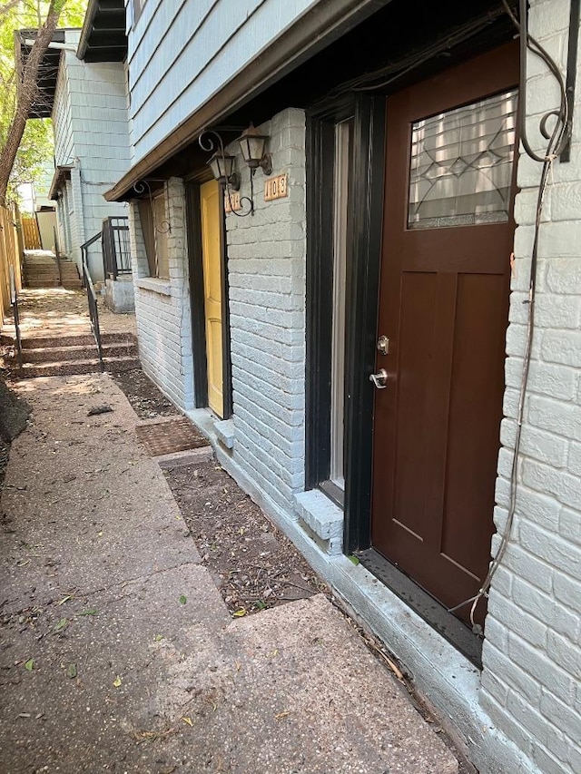 view of exterior entry with brick siding