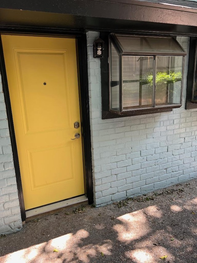 entrance to property featuring brick siding