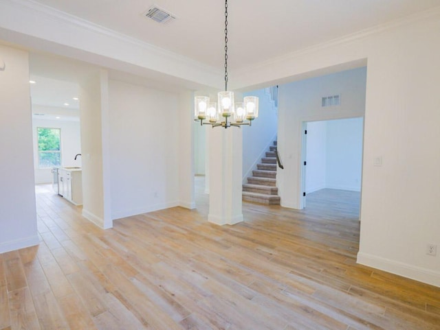 1705 Cayuga St, Leander, TX 78641 - spare room featuring a chandelier, light wood-type flooring, crown molding, stairs, and recessed lighting