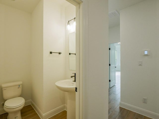 1705 Cayuga St, Leander, TX 78641 - bathroom featuring wood finished floors, toilet, and baseboards