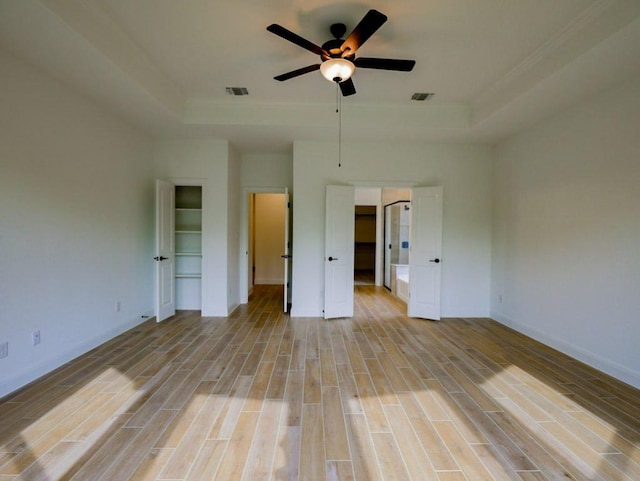 1705 Cayuga St, Leander, TX 78641 - unfurnished bedroom featuring a raised ceiling, ornamental molding, light wood-style floors, baseboards, and a ceiling fan