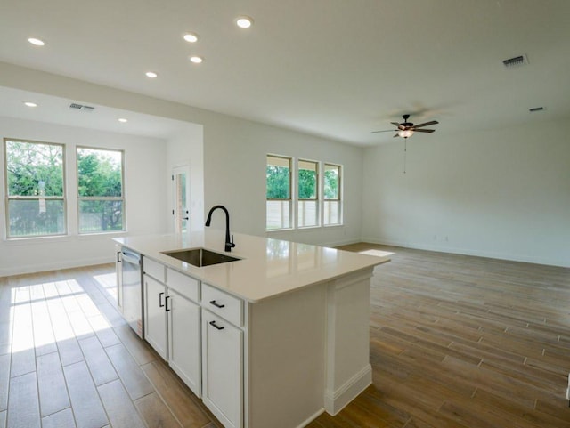 1705 Cayuga St, Leander, TX 78641 - kitchen with wood finished floors, stainless steel dishwasher, ceiling fan, open floor plan, and recessed lighting