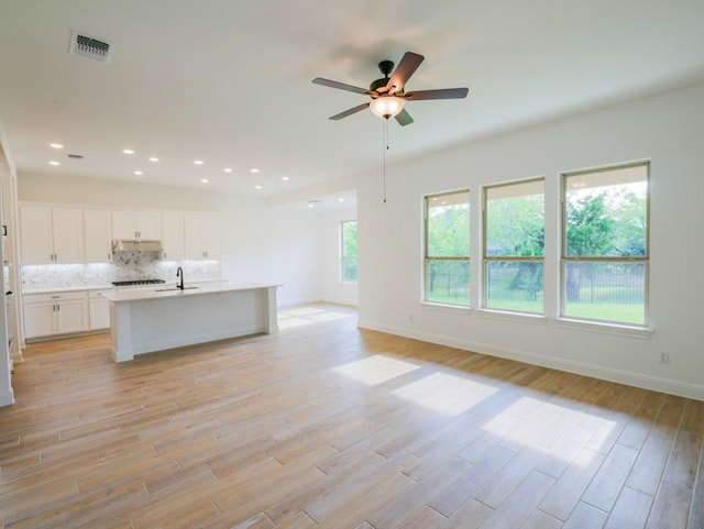 1705 Cayuga St, Leander, TX 78641 - unfurnished living room featuring light wood-type flooring, a ceiling fan, baseboards, a sink, and recessed lighting