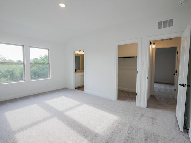 1705 Cayuga St, Leander, TX 78641 - unfurnished bedroom featuring light colored carpet, a spacious closet, ensuite bath, recessed lighting, and a closet