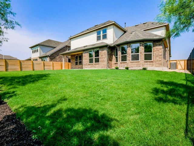 1705 Cayuga St, Leander, TX 78641 - rear view of house with a fenced backyard, brick siding, and roof with shingles