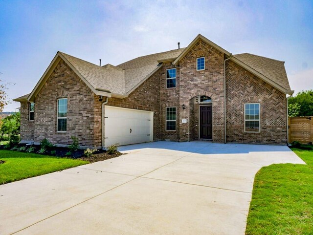 1705 Cayuga St, Leander, TX 78641 - traditional-style home featuring concrete driveway, a shingled roof, a garage, and brick siding